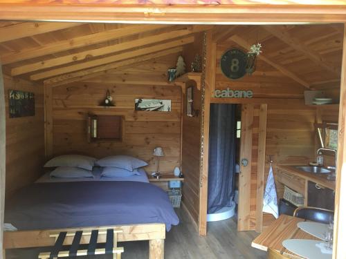圣让多尔普la Cabane dans les Arbres的小木屋内一间卧室,配有一张床