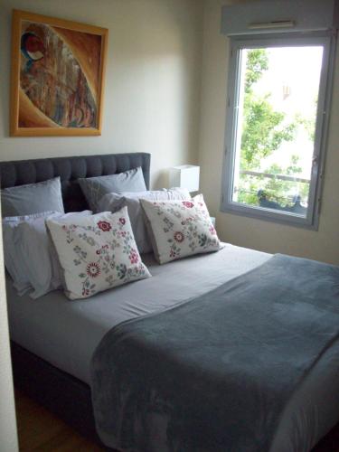 南特T2 avec box proche Graslin的卧室配有带枕头的床铺和窗户。
