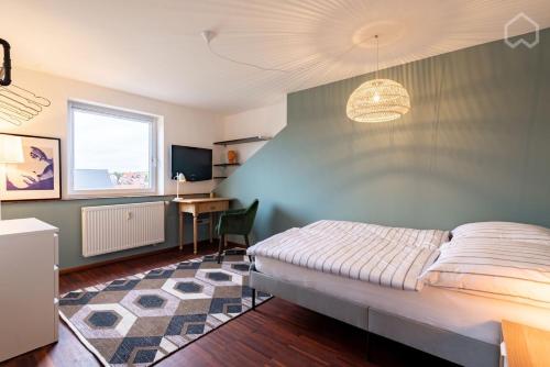 讷凡姆伊恩涅德巴110qm Countryside Loft的一间卧室配有一张床、一张书桌和一台电视