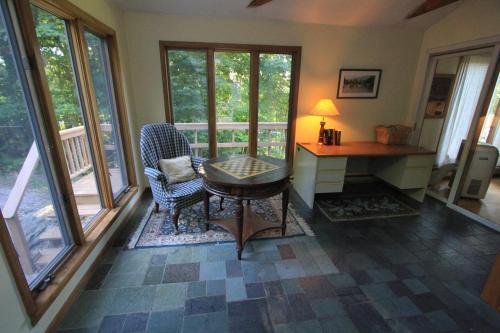 斯托Quaint Stowe Cabin的客厅配有桌子、椅子和窗户
