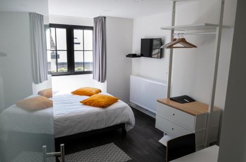拉罗什-阿登PANACHE - BIKE EN SLEEP HOTEL的一间卧室配有带橙色枕头的床