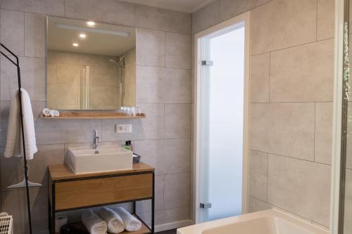 拉罗什-阿登PANACHE - BIKE EN SLEEP HOTEL的一间带水槽、浴缸和镜子的浴室