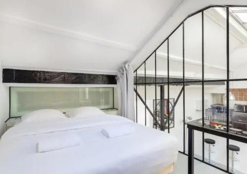 巴黎Atelier d Artiste Le Marais Paris - exceptionnel !的一间带白色床的卧室和一个阳台