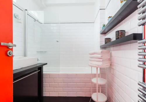巴黎Atelier d Artiste Le Marais Paris - exceptionnel !的浴室设有水槽和粉红色瓷砖淋浴。