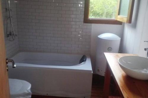 新帕尔米拉Rinconcito - Casa de descanso y río en Punta Gorda, Uruguay的带浴缸和盥洗盆的浴室