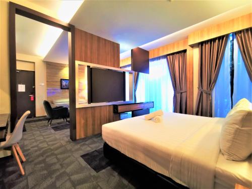 新山Prestigo Hotel - Johor Bharu的配有一张床和一台平面电视的酒店客房