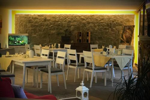 布雷佐内加尔达Villa Torre - Atmosfera Romantica的一间设有白色桌椅和石墙的餐厅