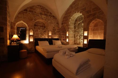 马尔丁贞协里耶酒店的一间卧室设有两张床和石墙