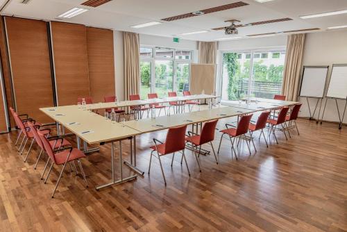 巴德哥依斯恩乌尔福赫格伊斯尔姆勒酒店的大型会议室,配有长桌子和椅子