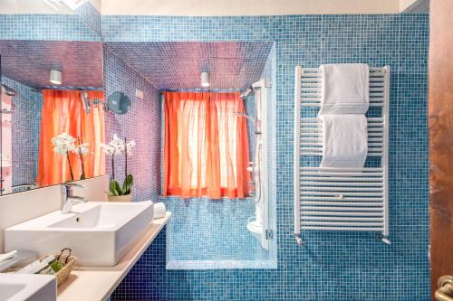 罗马托瑞科隆纳公寓酒店的蓝色瓷砖浴室设有水槽和淋浴