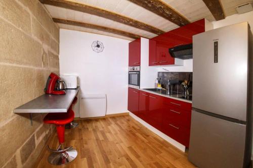 多勒DUPLEX COSY Superdole - Classé 3 étoiles的厨房配有红色橱柜和白色冰箱