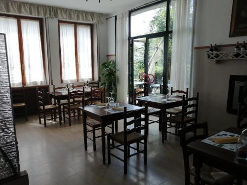 毕威格利亚努La Locanda di Bivigliano的用餐室设有桌椅和窗户。
