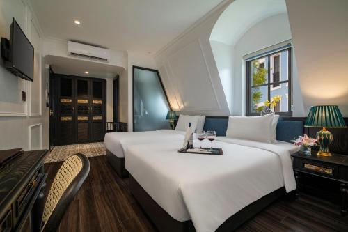 下龙湾Ha Long Essence Hotel的酒店客房设有两张床和电视。
