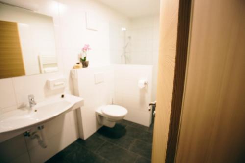 摩梭舍瑙酒店的浴室配有白色卫生间和盥洗盆。