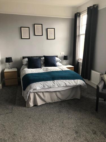 埃文河畔斯特拉特福卡尔登旅馆的一间卧室配有一张带蓝色床单和枕头的床。