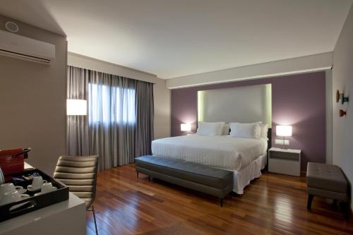 库里提巴库里提巴五号NH酒店的配有一张床和一张书桌的酒店客房