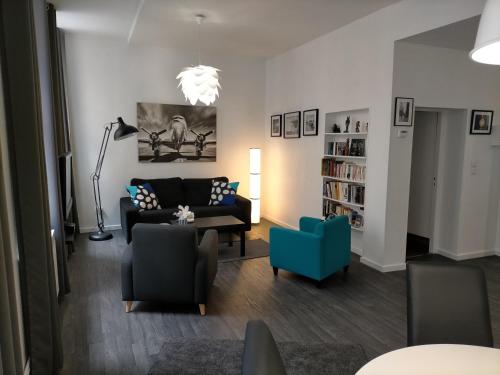 梅斯Le FOURNIRUE T2的带沙发和蓝椅的客厅