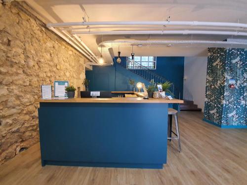 LatresneBrit Hotel Bordeaux Arena的一间设有蓝色柜台和石墙的办公室