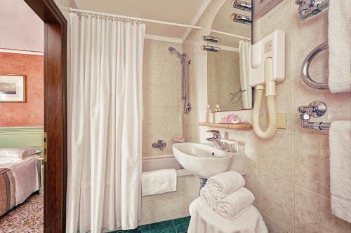 威尼斯菲兰其酒店的浴室配有盥洗盆和浴缸。