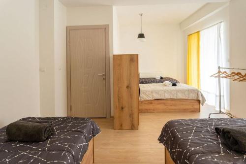 斯科普里Hostel Denica的一间卧室设有两张床,一扇门设有窗户