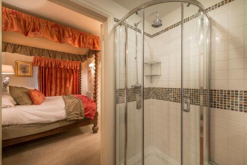 昂德尔The Talbot Hotel, Oundle , Near Peterborough的带淋浴的浴室和客房内的一张床