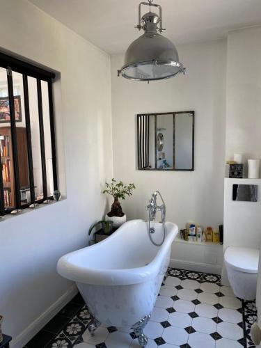 马恩河畔维列Maison du bonheur的浴室设有白色浴缸及镜子