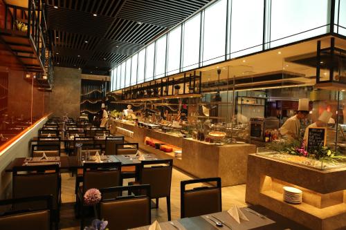 深圳深圳富临大酒店（近罗湖口岸和万象城和东门，提供限时升级特惠）的餐厅设有桌子,厨师准备食物