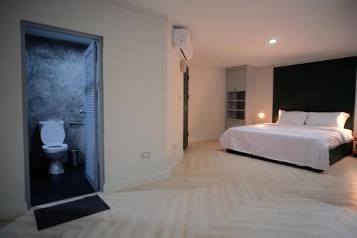 曼谷Silom Apartment Close to BTS +WIFI+Netflix的卧室配有白色的床和卫生间