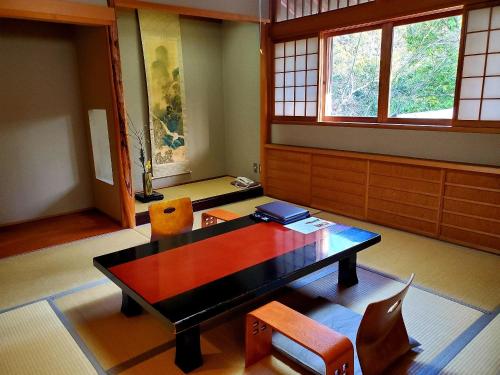 由布市料亭田野仓酒店的客房设有桌椅和窗户。