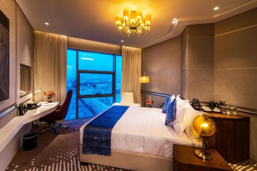 多哈VIP Hotel Doha Qatar的酒店客房设有一张床和一个大窗户