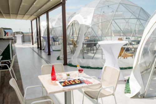 奥拉迪亚尼维斯SPA疗养酒店的阳台上的一张桌子和一张带帐篷的食品托盘