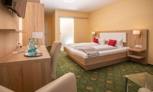 伦布鲁Hotel Garni Zur Alten Post的酒店客房配有一张床铺和一张桌子。