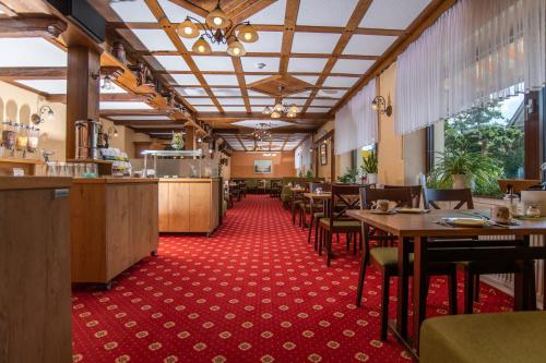 伦布鲁Hotel Garni Zur Alten Post的一间设有桌椅和红地毯的餐厅