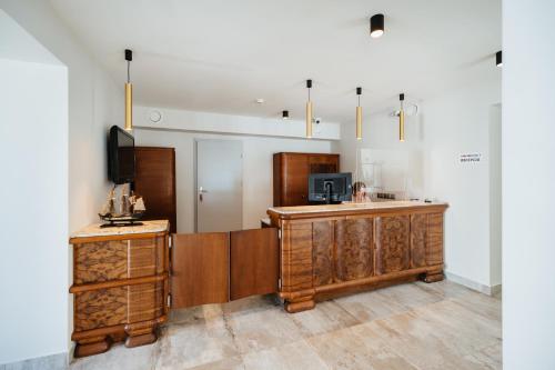 厄尔科Horeka Hotel & SPA的一个带木制橱柜的厨房和客房内的电视