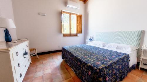 洛克里La Casa del carrubo di Borgo Carbone的一间卧室设有一张床和一个窗口