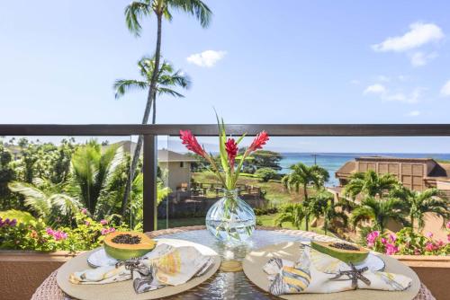 拉海纳Kahana Villa F406的一张桌子,上面放着两盘食物,享有海景