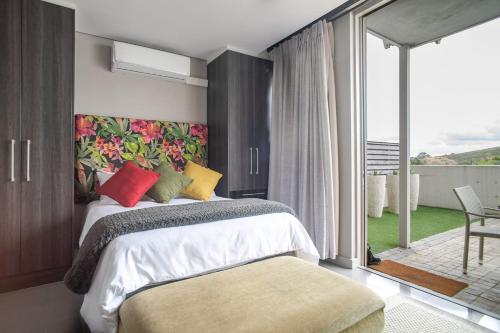 斯泰伦博斯Lux Andringa Walk Apartments的一间带大床的卧室和一个阳台