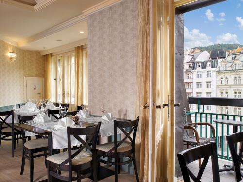 卡罗维发利埃莱凡特EA酒店的一间带桌椅的用餐室和窗户。
