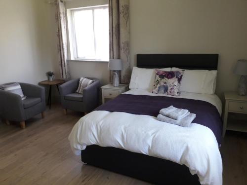 洛赫雷Lakeside Loughrea的一间卧室配有一张大床和两条毛巾