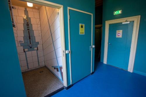 乌得勒支斯特罗韦斯旅舍的一间空浴室,拥有蓝色的墙壁和两个门