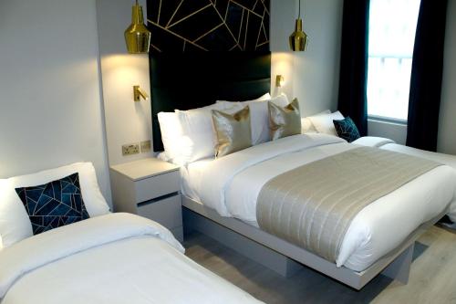 伦敦NOX Waterloo的配有白色床单的酒店客房内的两张床
