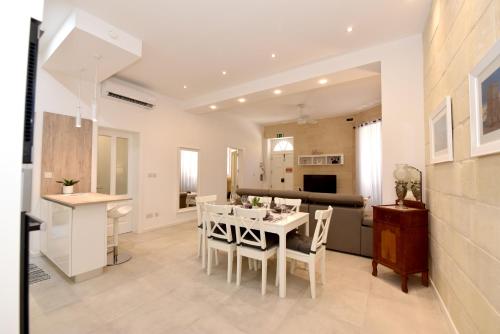 维洛里奥萨Luxury Maisonette的厨房以及带白色桌椅的用餐室。