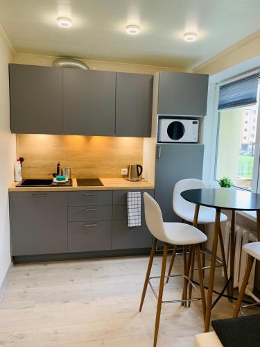 瓦尔加Sepa Apartment的厨房配有灰色橱柜和桌椅