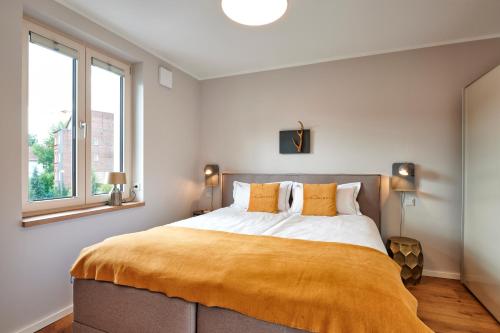 艾森纳赫Suites MITTE - Aparthotel的一间卧室配有一张带黄色毯子的大床