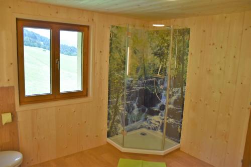 施瓦岑贝格Ferienhaus Brittenberg的木制房间,设有玻璃淋浴间和窗户