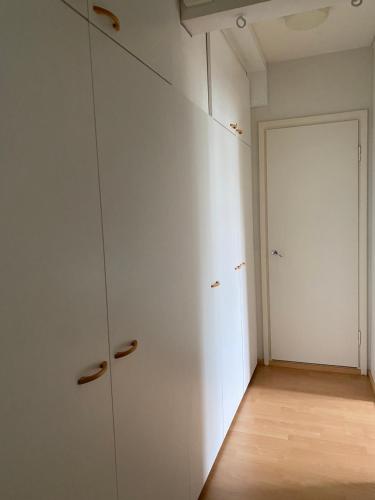 科特卡Apartments ”Enkeli”的一个空房间,有白色的橱柜和门