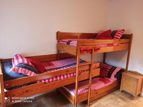 圣洛伦索-德莫鲁尼斯Cal Mosqueta的配有红色枕头的客房内的两张双层床