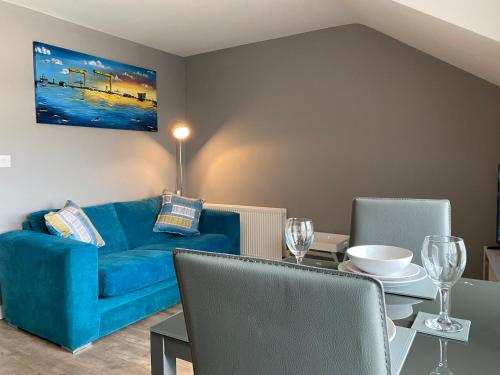 波塔当VIP Church Loft Apartment的客厅配有蓝色的沙发和桌子