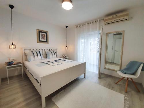 扎达尔Viva Zadar的白色卧室配有一张白色的大床和一把椅子