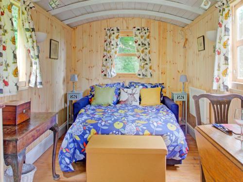 汤顿Hill view Holiday Home with Garden的卧室配有一张床铺,位于带木墙的房间内